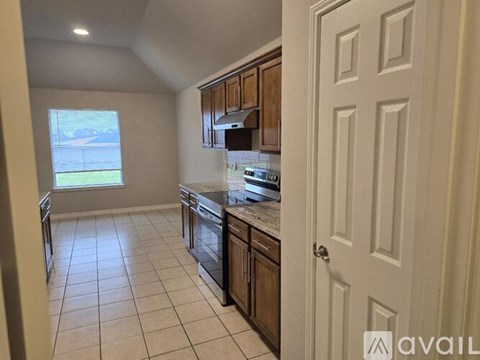 A kitchen with a white door and brown cabinets.