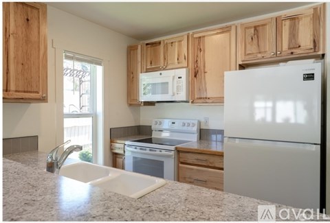 A kitchen with wooden cabinets and a white refrigerator.