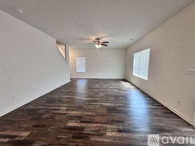 A room with wooden flooring and a ceiling fan.