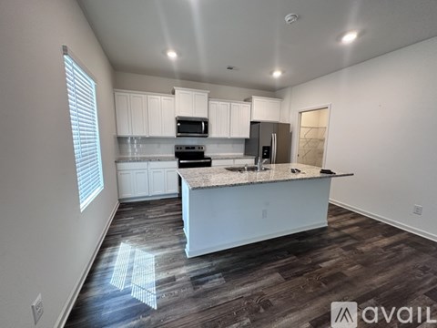 A kitchen with white cabinets and a wooden island.