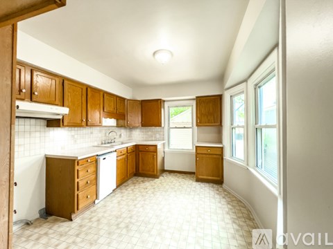 A kitchen with wooden cabinets and a white dishwasher.