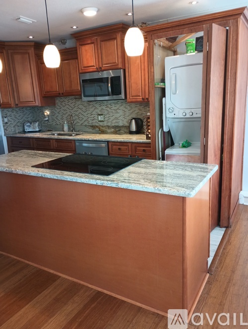 A kitchen with wooden cabinets and a granite countertop.