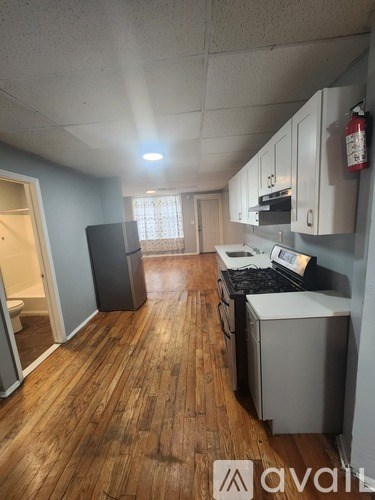 A kitchen with wooden floors and a white ceiling.