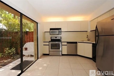 A kitchen with a refrigerator, oven, and sink.