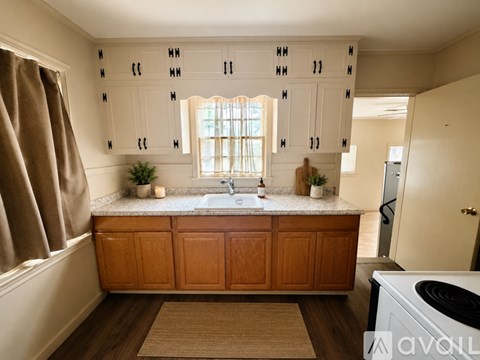 A kitchen with wooden cabinets and a window above the sink.