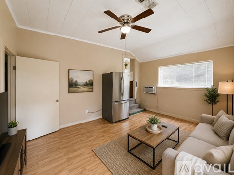 A living room with a ceiling fan and a painting on the wall.