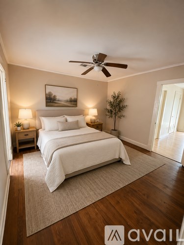 A bedroom with a bed, nightstands, and a ceiling fan.