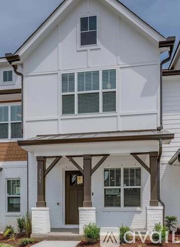 A white house with a brown door and windows.