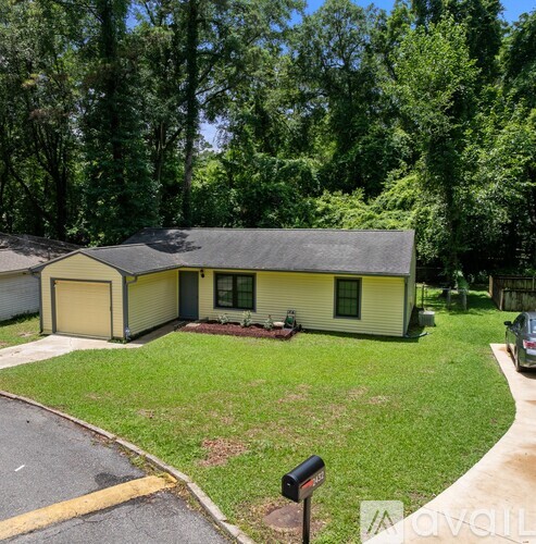A house with a garage and a driveway in front of it.