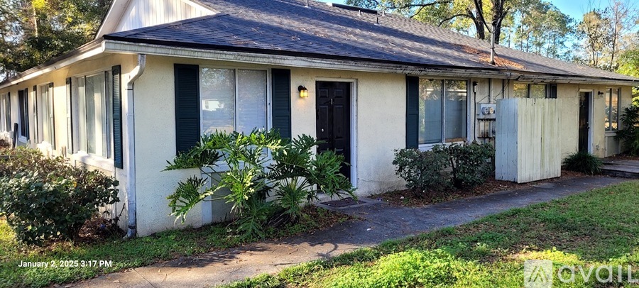 A small white house with a black door and windows.
