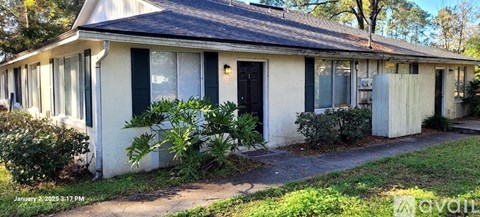 A small white house with a black door and windows.