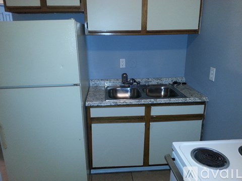 A kitchen with a white fridge, a sink and a stove.