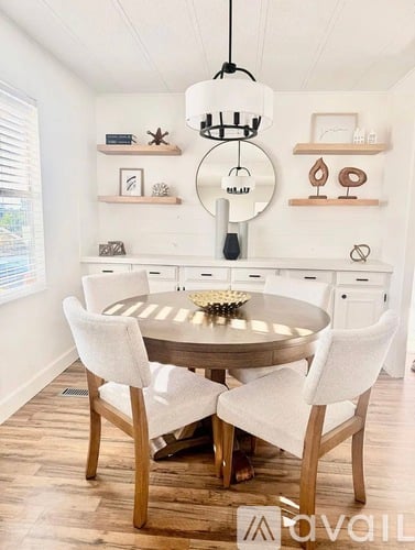 A dining room with a round table and chairs.