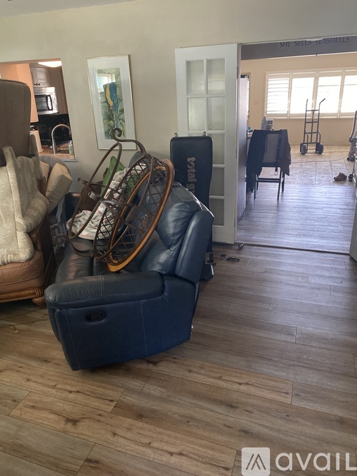 A blue sofa with a wooden rocking chair in front of it.