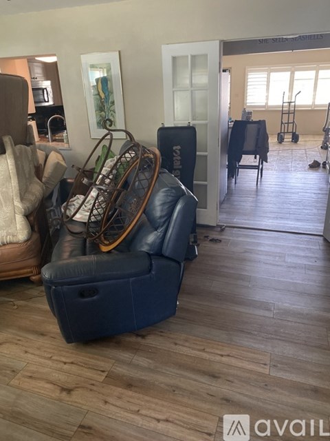 A blue sofa with a wooden rocking chair in front of it.