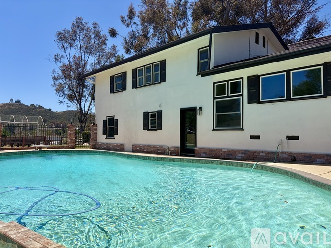 A house with a pool in front of it.