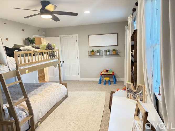 A bedroom with a bunk bed and a small table with chairs.