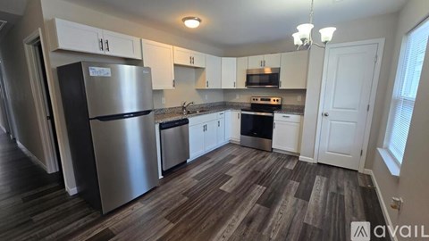 A kitchen with a refrigerator, oven, and microwave.