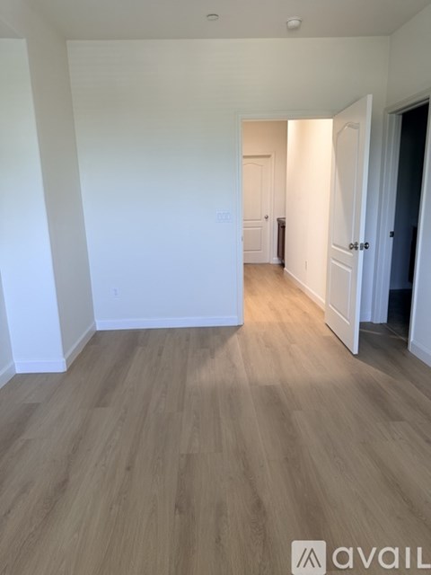 A room with wooden flooring and white walls.