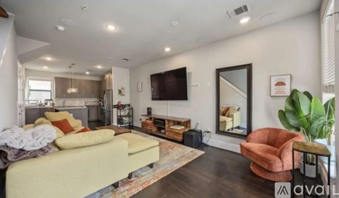 A living room with a yellow sofa and a television on the wall.