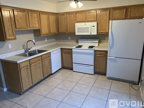 A kitchen with wooden cabinets and white appliances.