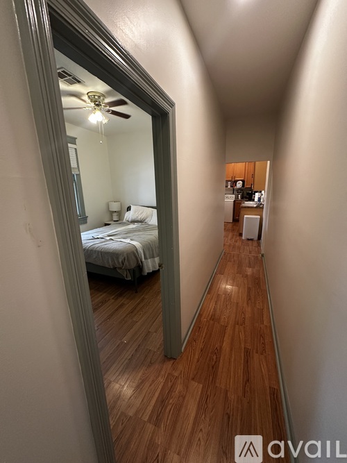 A bedroom with a bed and a ceiling fan is visible through a mirror.