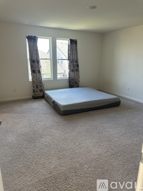 A bedroom with a bed and a window with curtains.