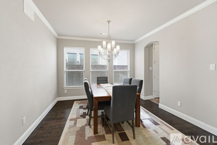 A dining room with a table and chairs.