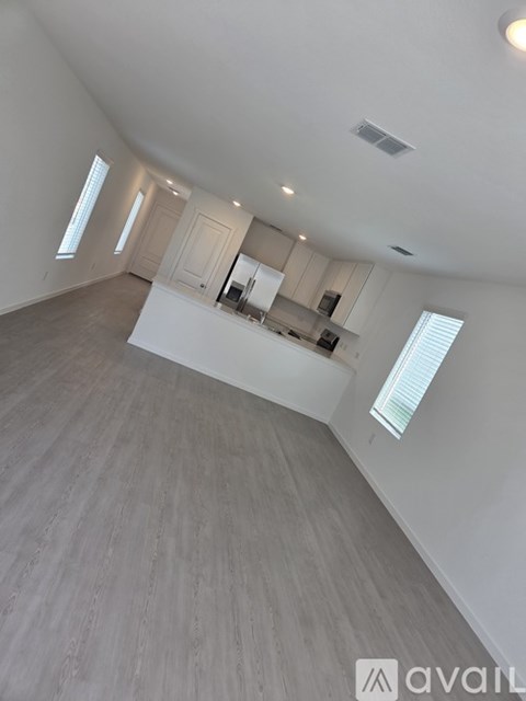 A spacious room with a kitchen area and a large window.
