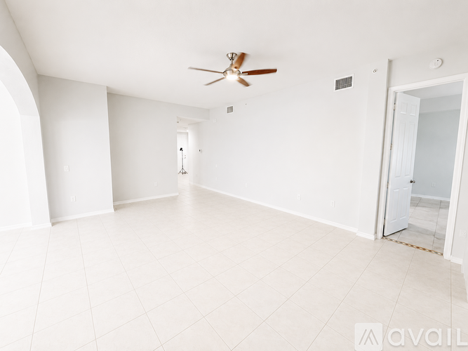 A spacious room with a ceiling fan and tiled flooring.