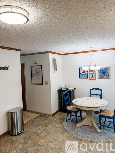 A dining room with a white table and blue chairs.