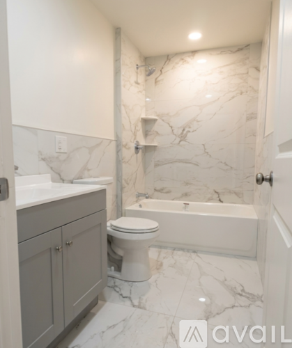 A bathroom with marble walls and a white toilet.