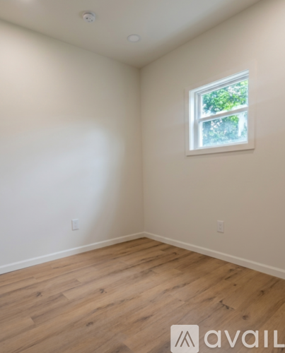 A room with a window and wooden flooring.