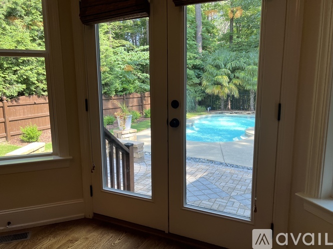 A view of a pool through a sliding glass door.