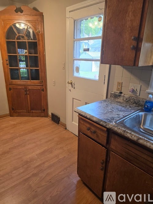 A kitchen with wooden floors and a granite counter top.