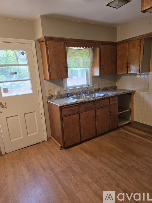 A kitchen with wooden cabinets and a white door.