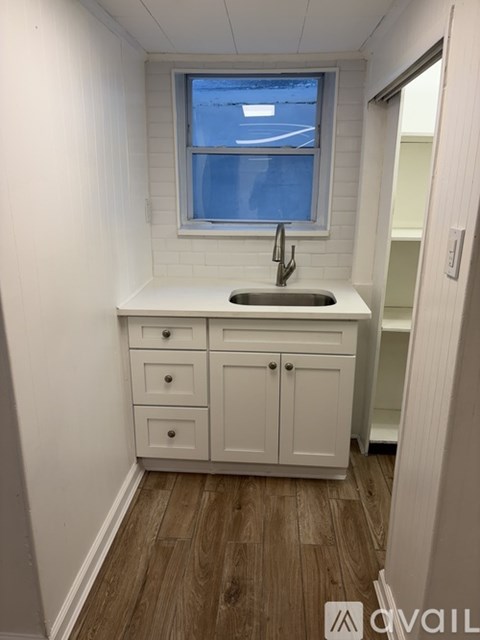 A small white kitchen with a window.