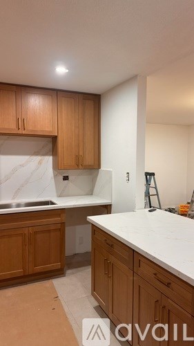 A kitchen with wooden cabinets and a marble countertop.