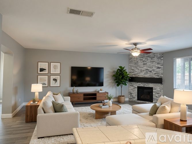 A living room with a white couch, a fireplace, and a television.