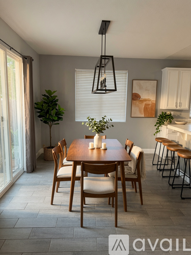 A dining room with a wooden table and chairs.