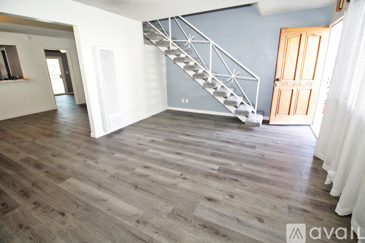 A wooden staircase with a metal railing in a room with wooden flooring.