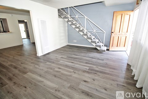 A wooden staircase with a metal railing in a room with wooden flooring.