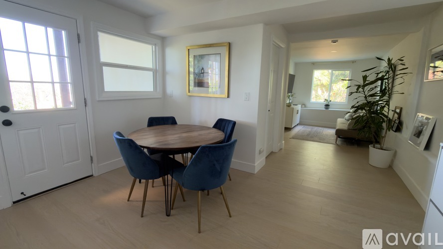 A dining room with a round table and blue chairs.