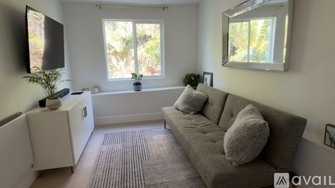 A living room with a grey couch and a white cabinet.