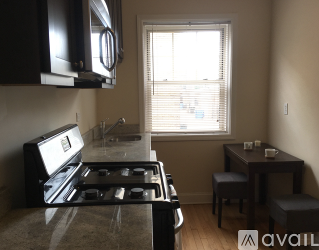 A kitchen with a black stove top oven and a microwave above it.