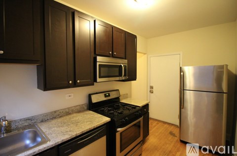 A kitchen with dark brown cabinets and stainless steel appliances.
