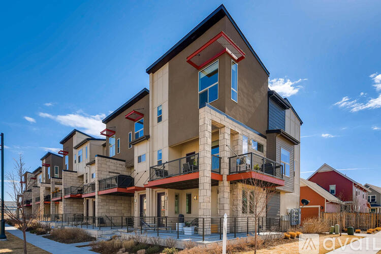 A modern multi-story building with balconies and a variety of windows.