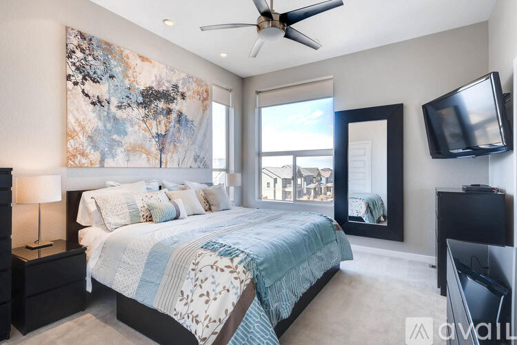 A bedroom with a large bed and a ceiling fan.