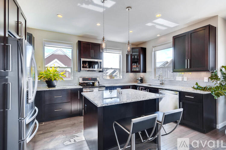A modern kitchen with dark wood cabinets and a large island.
