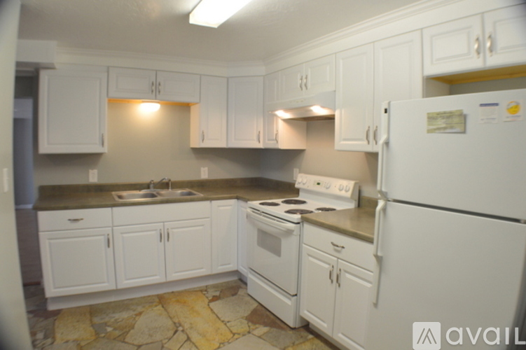 A kitchen with white cabinets and appliances.